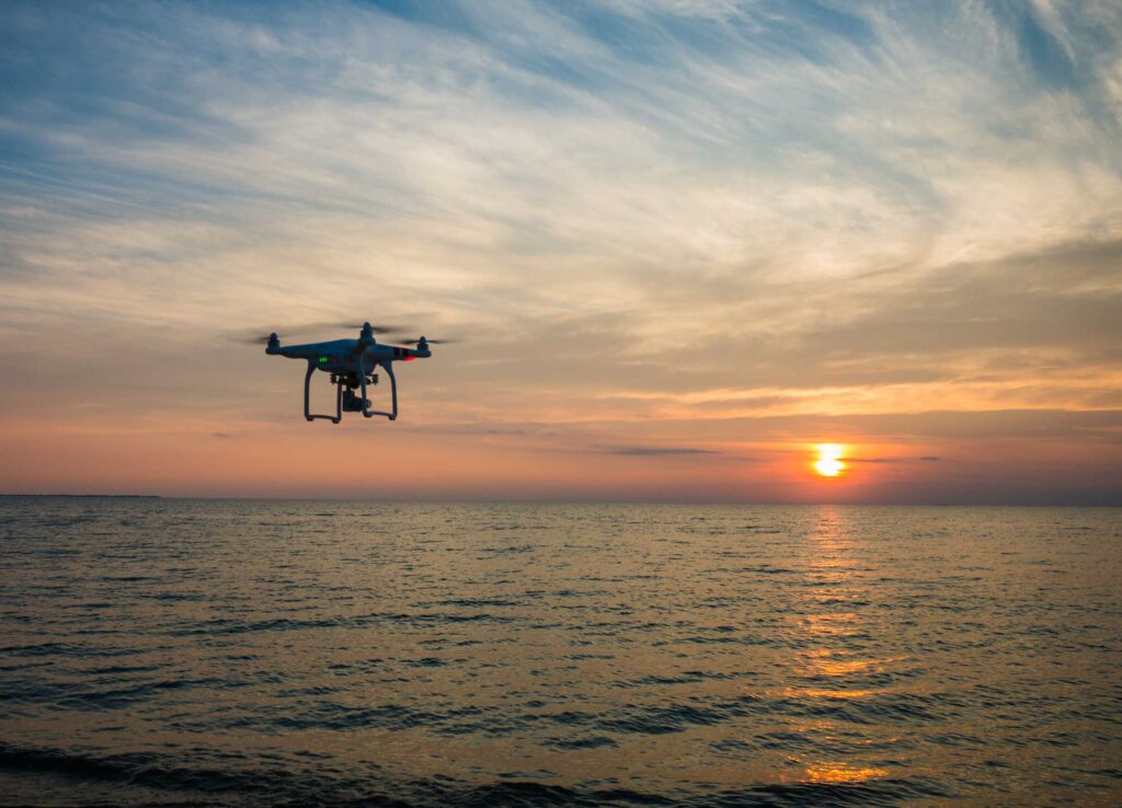 quadcopter flying over body of water