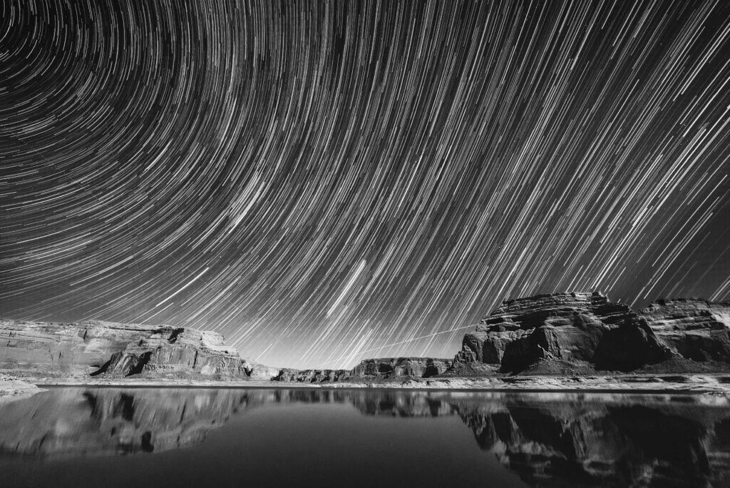 grayscale photography of calm body of water under sky