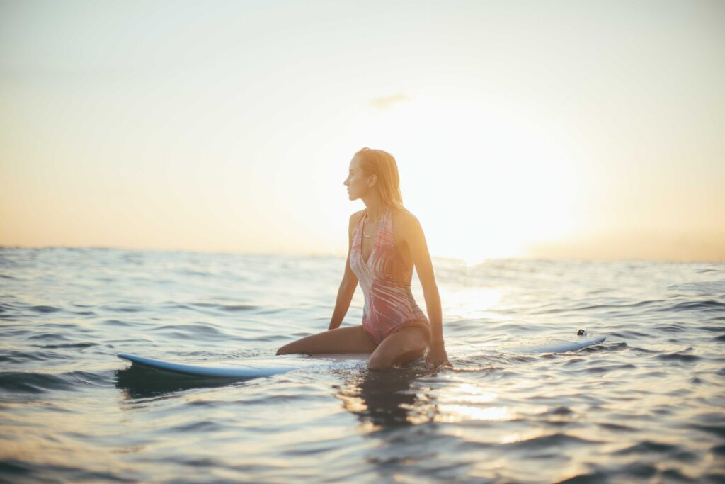 woman riding a blue surfboard in a body of water