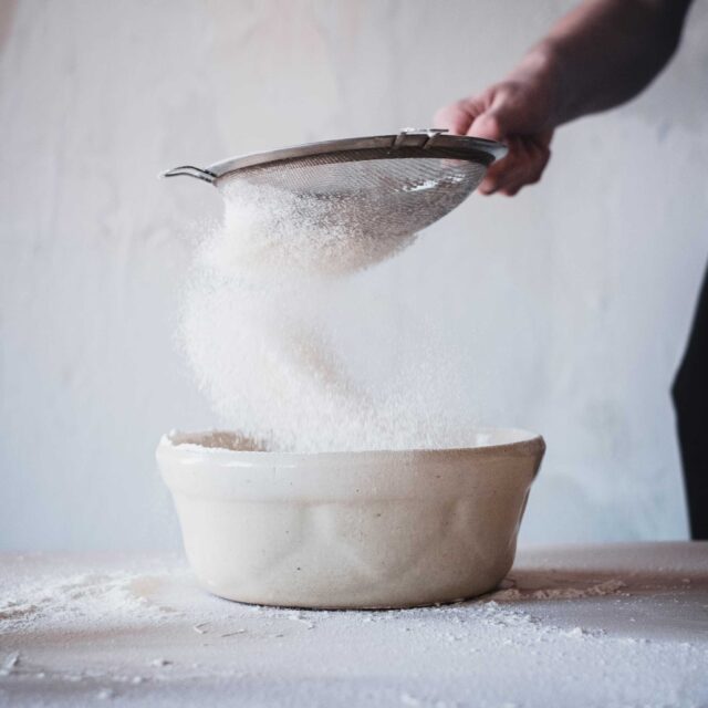 person pouring water on white ceramic bowl