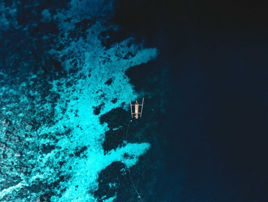 white boat on blue body of water