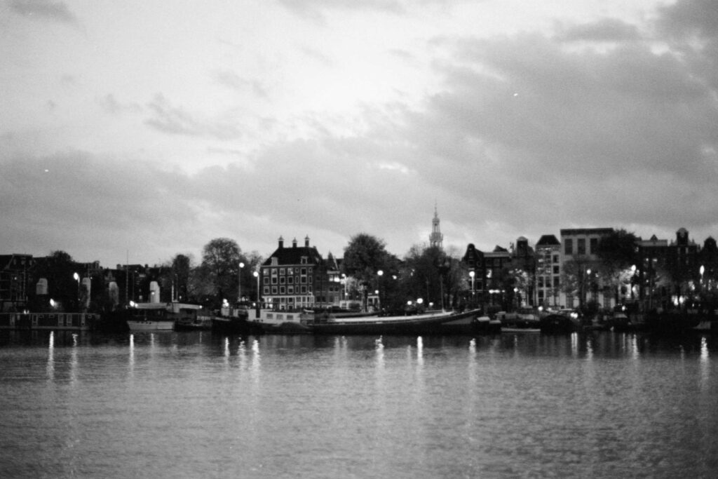 grayscale photo of city buildings near body of water