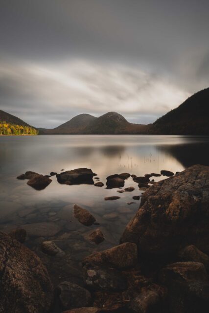 black rocks on body of water during daytime