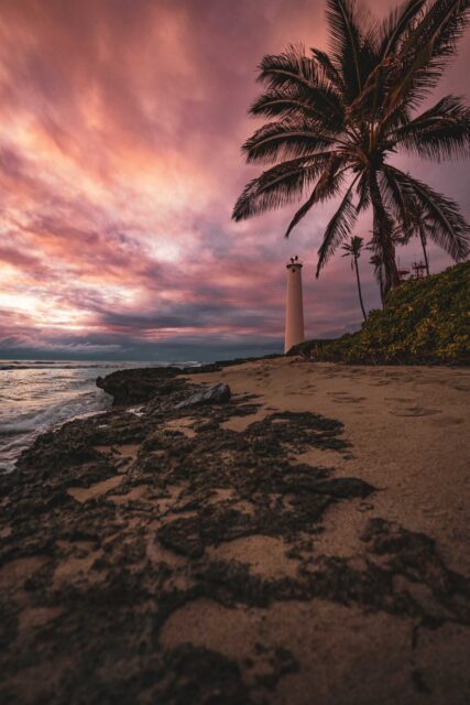 white lighthouse near body of water during sunset