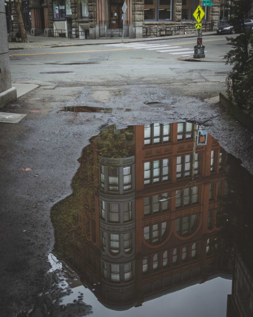 brown concrete building reflects on water