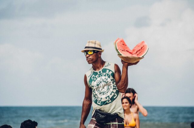 man holding sliced watermelons
