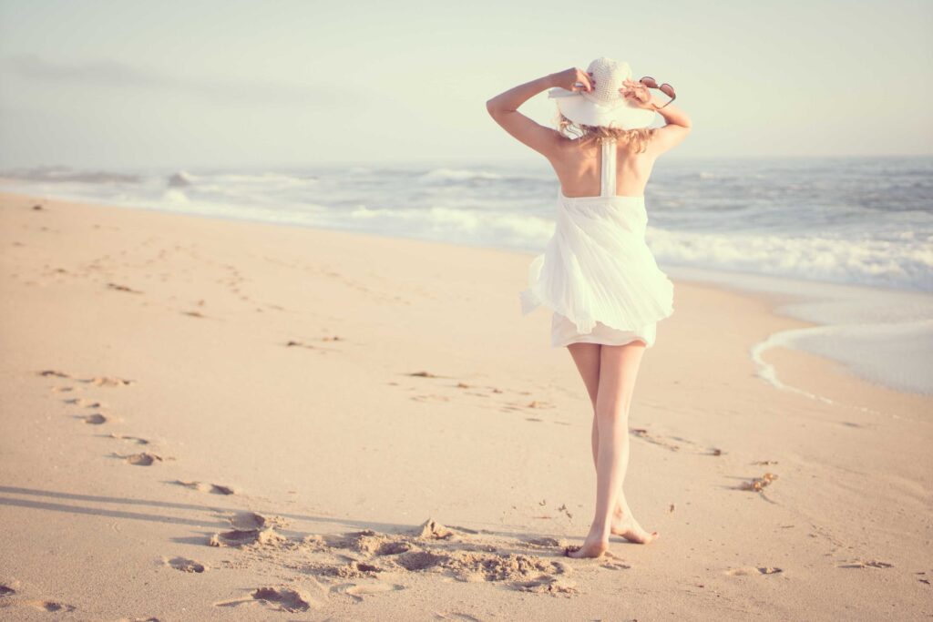 woman walking on beach during daytime